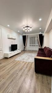 a large living room with a couch and a television at ЖК Lake town 3 in Almaty