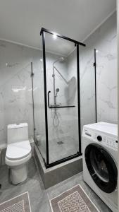 La salle de bains est pourvue de toilettes et d'un lave-linge. dans l'établissement ЖК Lake town 3, à Almaty