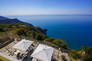 a view of the ocean from a resort with white umbrellas at Albergo Luna di Marzo in Volastra