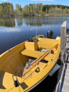 a yellow boat docked at a dock on a lake at Tarula Holiday Home in Melkoniemi