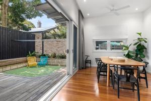 ein Esszimmer mit einem Tisch und Stühlen auf einer Terrasse in der Unterkunft Pure Elegance in Cooks Hill in Newcastle