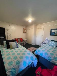 um quarto com 2 camas e um sofá em Swanson-Waitakere Stay in Scenic Sunrise em Auckland