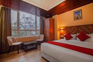 a bedroom with a bed and a large window at The Pahuna Retreat in Gangtok