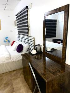a bedroom with a desk and a bed with a mirror at APARTMENT 30A in Abuja