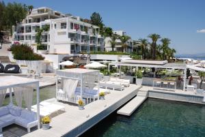 a house with chairs and a pool of water at Bilkent Casa Costa Hotel in Gundogan