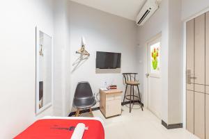 um quarto com uma secretária e uma televisão na parede em RedDoorz near Botani Square Mall em Bogor