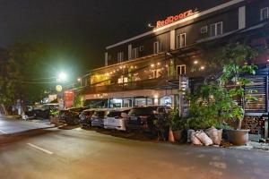 a row of cars parked outside of a building at night at RedDoorz near Botani Square Mall in Bogor