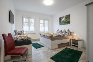 ein Zimmer mit 2 Betten und einem Stuhl darin in der Unterkunft Appartement am Westerntor III in Wernigerode