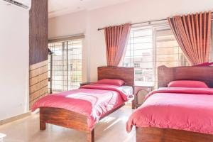 2 Betten in einem Schlafzimmer mit roten Decken und Fenstern in der Unterkunft Cielo in Islamabad
