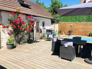 DampmartにあるGuest House proche Disneyland Paris Réouverture Piscine fin avrilの木製デッキ(テーブル、傘付)