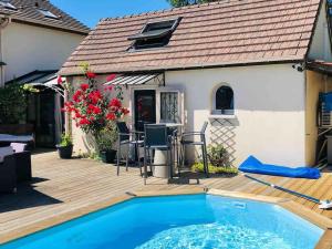 a house with a swimming pool on a wooden deck at Dépendance privée avec piscine proche Disneyland Paris in Dampmart