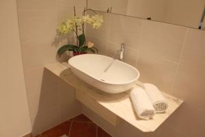 lavabo blanco en la encimera del baño en Mari's House by Alterego, en Castagnito