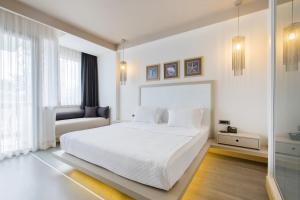 a white bedroom with a white bed and a couch at Bilkent Casa Costa Hotel in Gundogan +40 photos