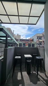 d'une terrasse sur le toit avec des tables et des tabourets. dans l'établissement Casa Kota Residence, à Jakarta