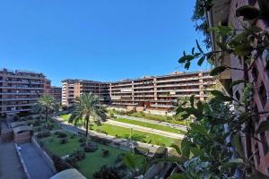 a view of a courtyard with palm trees and buildings at Copenaghen House in Fiumicino