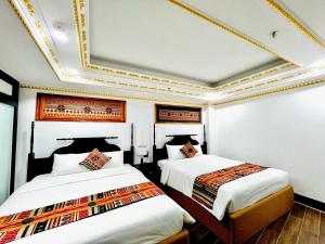 2 Betten in einem Zimmer mit einer Decke in der Unterkunft Trung Huyền Hotel in Sa Pa