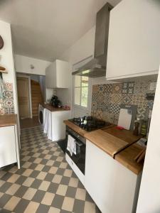 a kitchen with white cabinets and a checkered floor at Cosy Giverny in Giverny