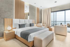 una camera con un grande letto e un soggiorno di Palma Beach Resort & Spa a Umm Al Quwain