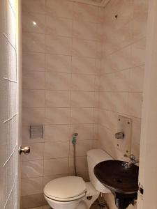 a small bathroom with a toilet and a sink at Orange Mangrove Pension House in Puerto Princesa City