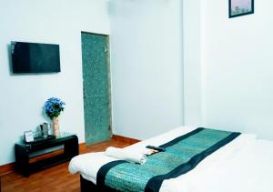 a bedroom with a bed and a tv and a table at Prince Reseidency Near Hari Nagar in New Delhi