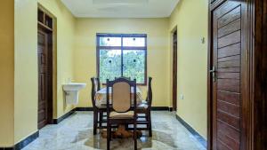 a dining room with a table and a window at MICHELLE HOME STAY in Hambayo