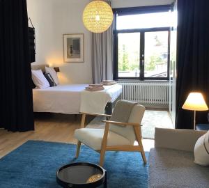 een slaapkamer met een bed, een tafel en een stoel bij Authentieke loft herenhuis in Oostende