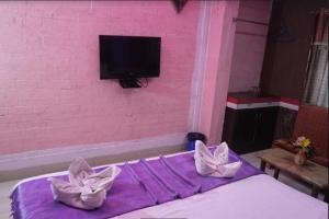 デーオーガルにあるHOTEL MAHAMAYA PALACEのピンクのベッドルーム(白い枕2つ付きのベッド1台付)