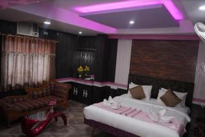 sypialnia z 2 łóżkami i fioletowym oświetleniem w obiekcie HOTEL MAHAMAYA PALACE w mieście Deoghar