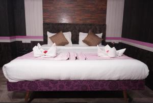 a large bed with white sheets and pillows on it at HOTEL MAHAMAYA PALACE in Deoghar