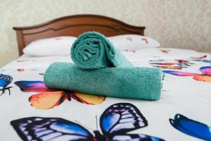 een groene handdoek bovenop een bed met vlinders bij Центр города Байтерек in Astana
