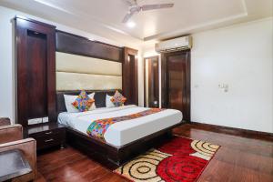 a bedroom with a large bed and a rug at FabHotel Rayplus - Prashant Vihar in New Delhi