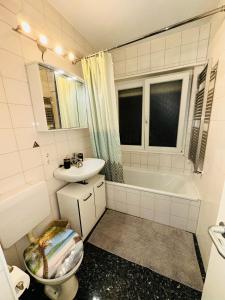 łazienka z toaletą, umywalką i wanną w obiekcie TULUM APARTMENTS - STUTTGART CITY w Stuttgarcie