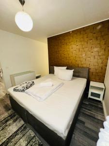 sypialnia z dużym łóżkiem z białą pościelą w obiekcie TULUM APARTMENTS - STUTTGART CITY w Stuttgarcie