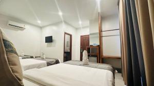 a hotel room with two beds and a mirror at Laluna Guesthouse in Siem Reap