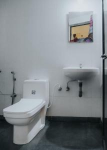 een badkamer met een wit toilet en een wastafel bij C9 Anjuna in Anjuna