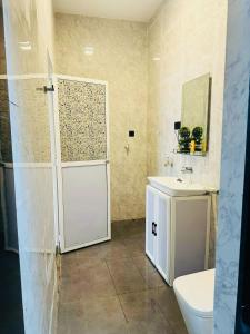 uma casa de banho com um WC, um lavatório e uma porta em Senu Resort Katunayaka em Katunayaka