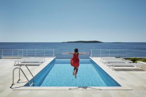 een vrouw die in een zwembad springt bij Villa Roca in Vis