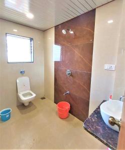 a bathroom with a toilet and a sink and a shower at Vinayaka Holiday Homes - Infinity Pool and Breathtaking Valley View in Panchgani
