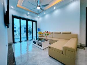 a living room with a couch and a ceiling fan at Phượng Hoàng villa - bể bơi, phòng karaoke, sân Pickleball, xe địa hình, xe đạp đôi in Ha Long