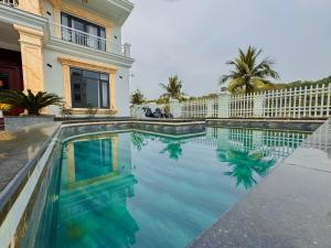 a swimming pool in front of a house at Phượng Hoàng villa - bể bơi, phòng karaoke, sân Pickleball, xe địa hình, xe đạp đôi in Ha Long
