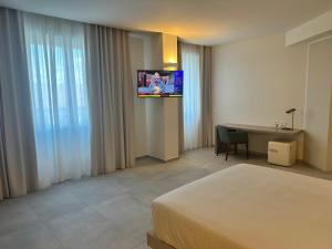 a hotel room with a bed and a desk and a television at Al Suite in Lissone