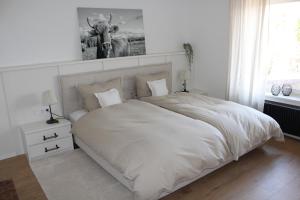 a bedroom with a white bed with a deer picture on the wall at Haus Sonnenhang Wohnung 1 in Stiefenhofen