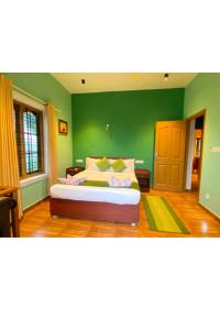 una camera da letto con pareti verdi e un grande letto di The two bedroom homestay a Madikeri