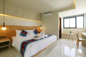 um quarto com uma cama grande com uma flor em LA PINO HOTEL em Songkhla