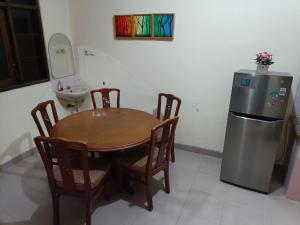 ジョグジャカルタにあるNdalem Cemara Homestayのテーブルとステンレス製の冷蔵庫を備えたキッチン +4枚の写真