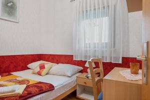 a small bedroom with a bed and a window at Pansion Adria Haus in Posedarje