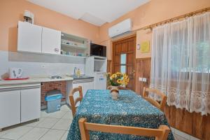 a kitchen with a table with a vase of flowers on it at Pansion Adria Haus in Posedarje