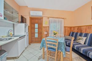 a kitchen and living room with a table and a couch at Pansion Adria Haus in Posedarje