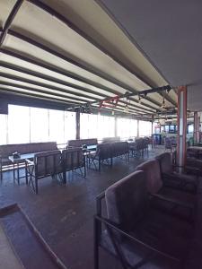une pièce vide avec des chaises, des tables et des fenêtres dans l'établissement ASKAR PORT OTEL, à Tasucu