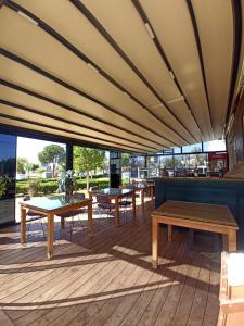 a patio with tables and benches on a deck at ASKAR PORT OTEL in Tasucu